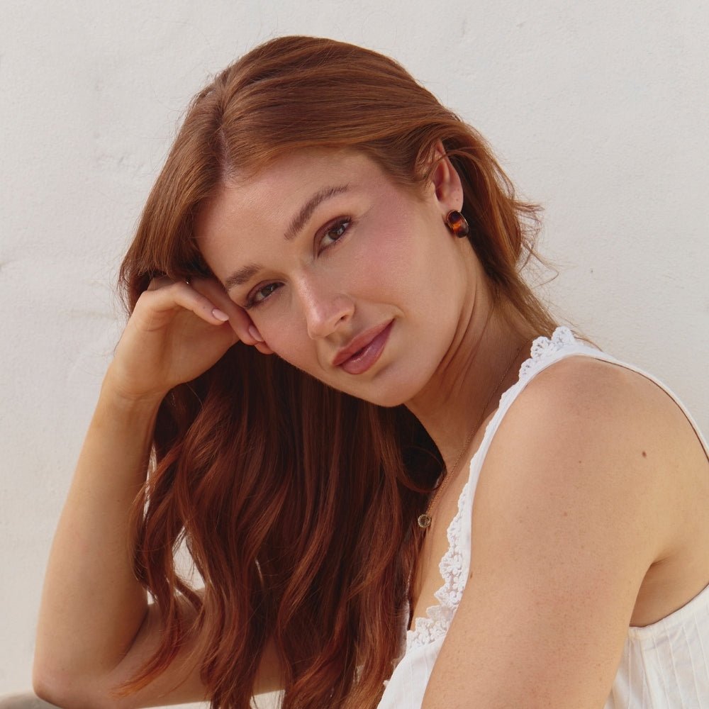 Amber Gold Hoop Earrings, model wearing an amber stud earring, hand to head